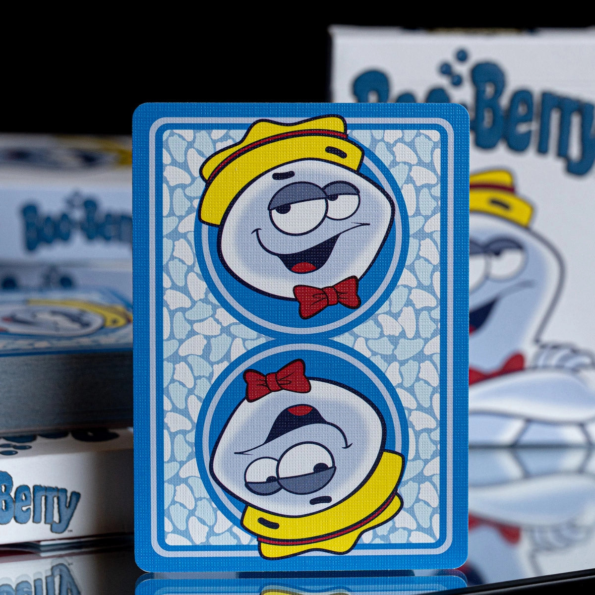 Boo Berry card back with mirrored ghost portraits, yellow hats, red bow ties, and a blue-and-white patterned background.
