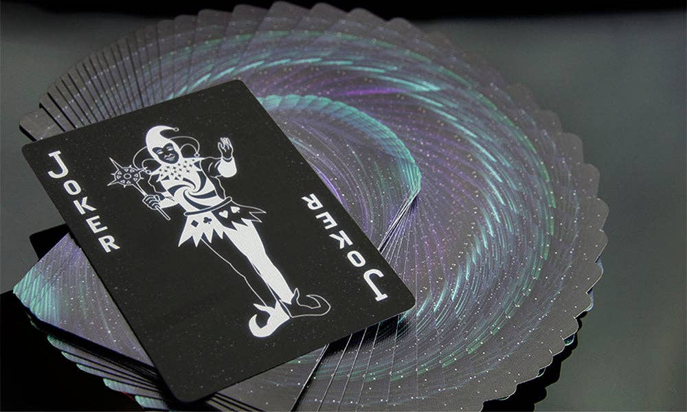 Black Joker card from a deck of cards with a colorful swirling design in the background.