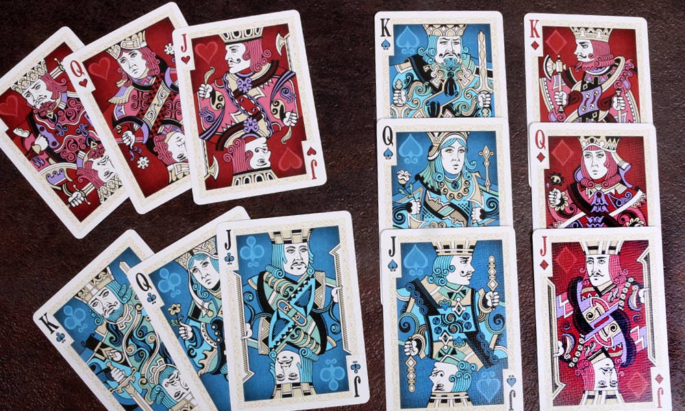 Playing cards with colorful designs on a dark surface