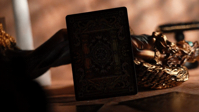Decorative black deck with intricate patterns on a wooden surface with gold accents.
