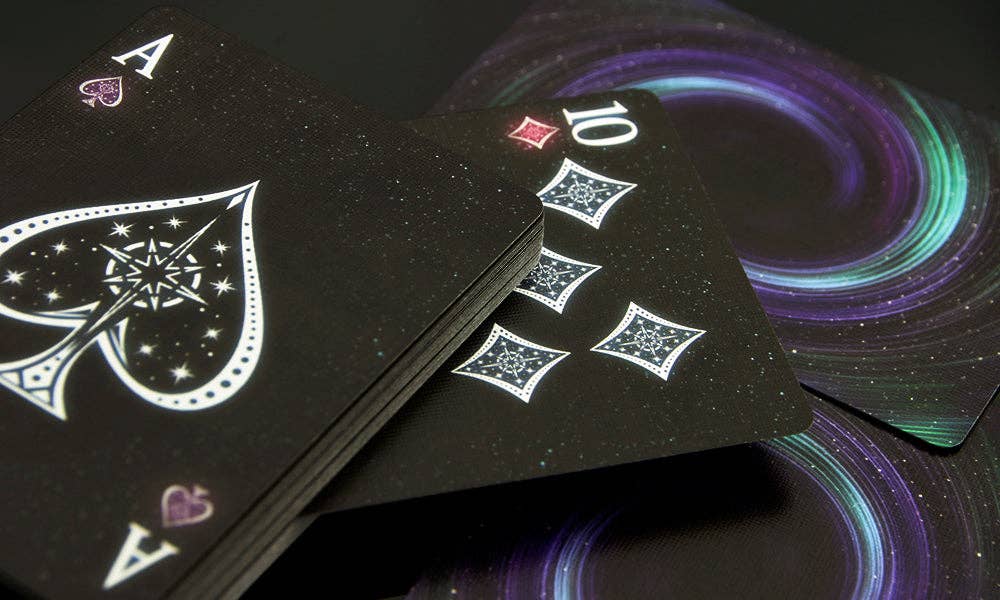 Black playing cards with white designs on a dark background