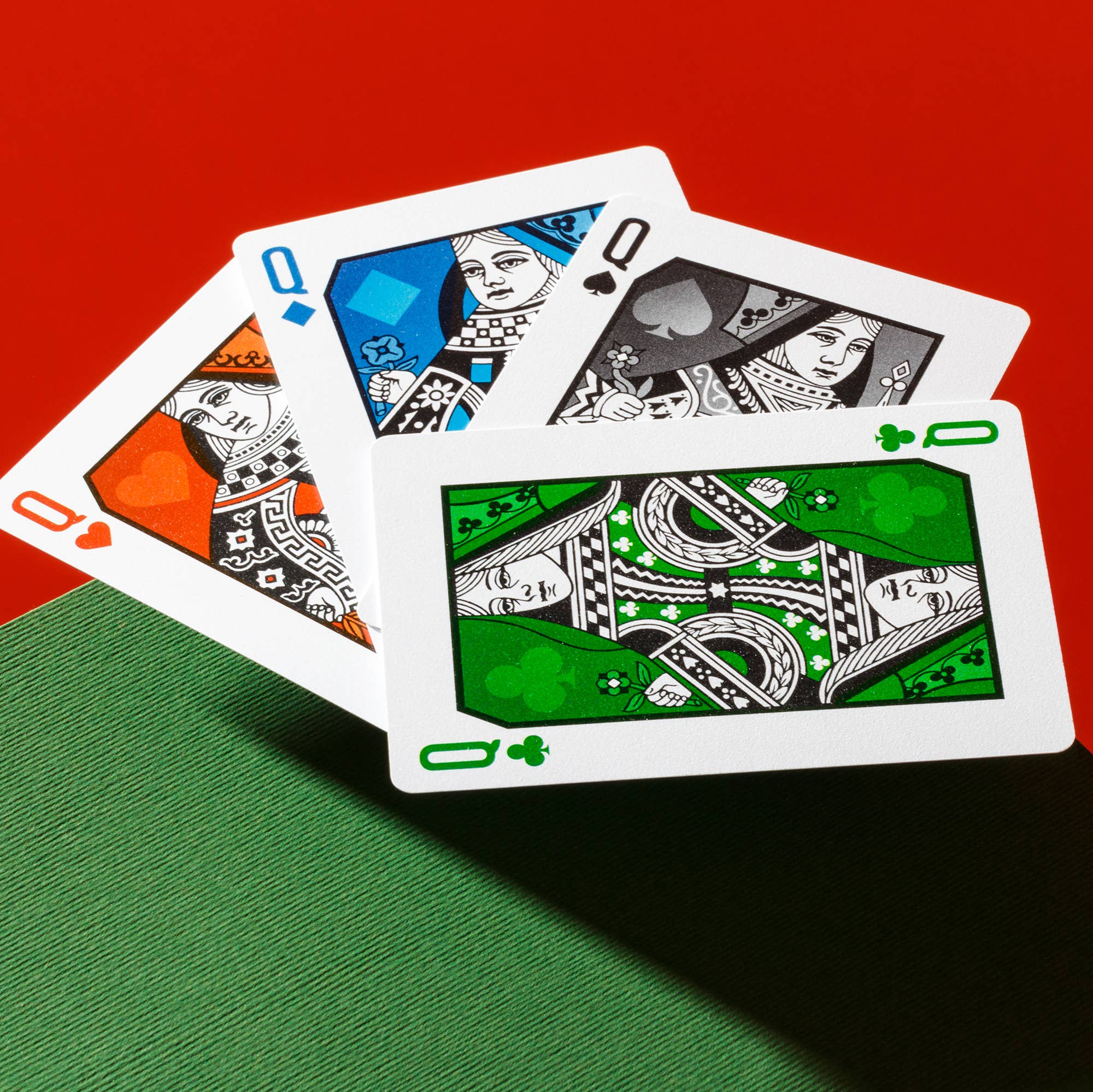 Four Vanda Aces Red playing cards on a red and green surface