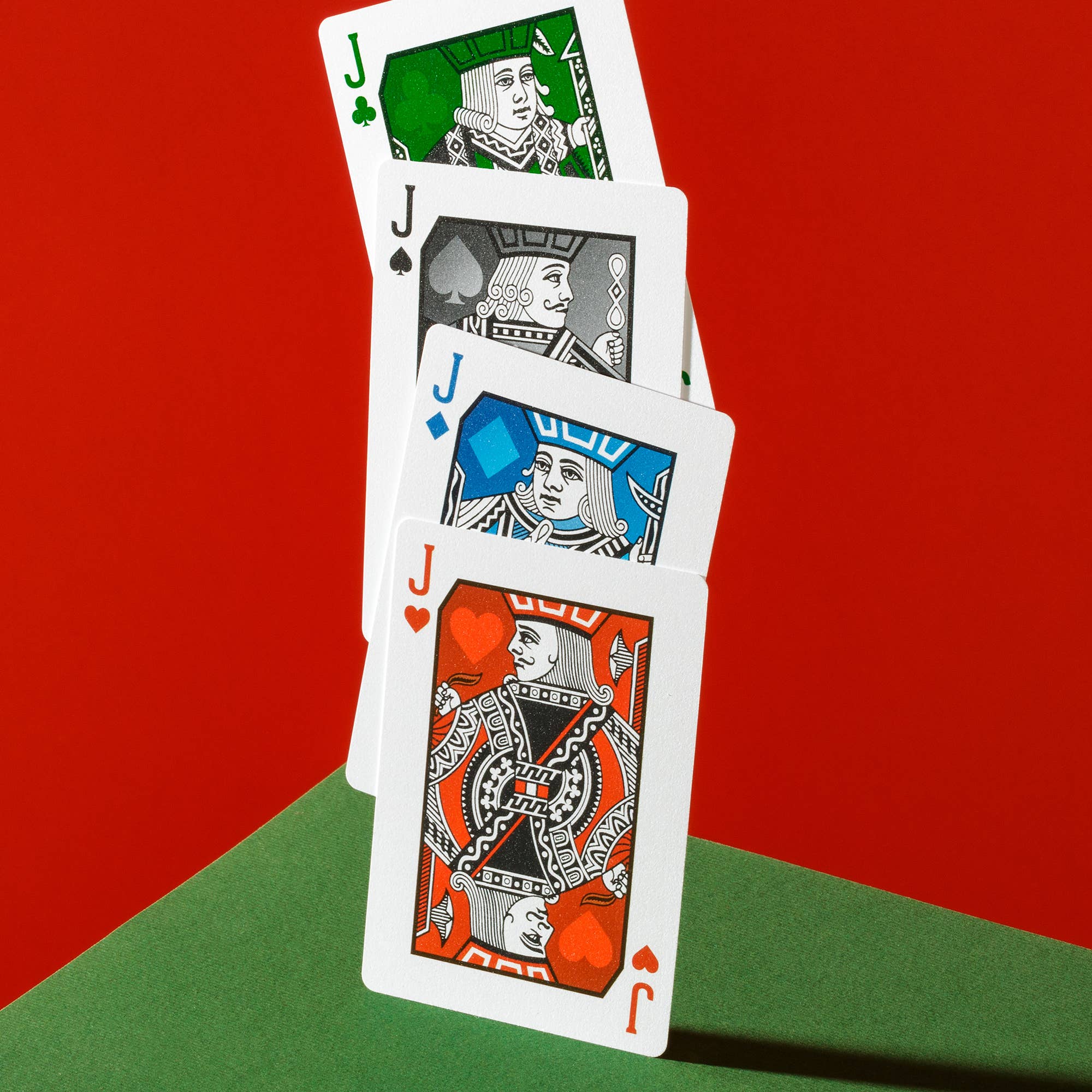 Four Vanda Aces Red playing cards with different suits on a red and green background