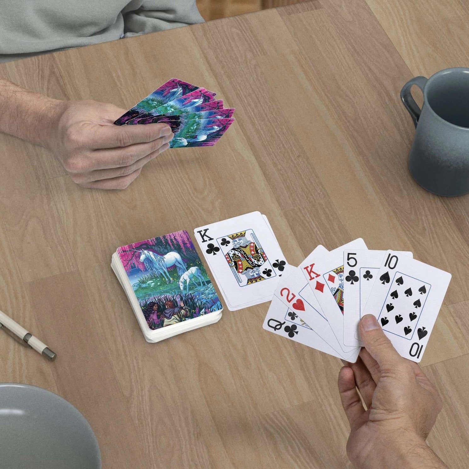 Finding Unicorns jumbo-index playing cards in use at a table with magical unicorn scenic backs