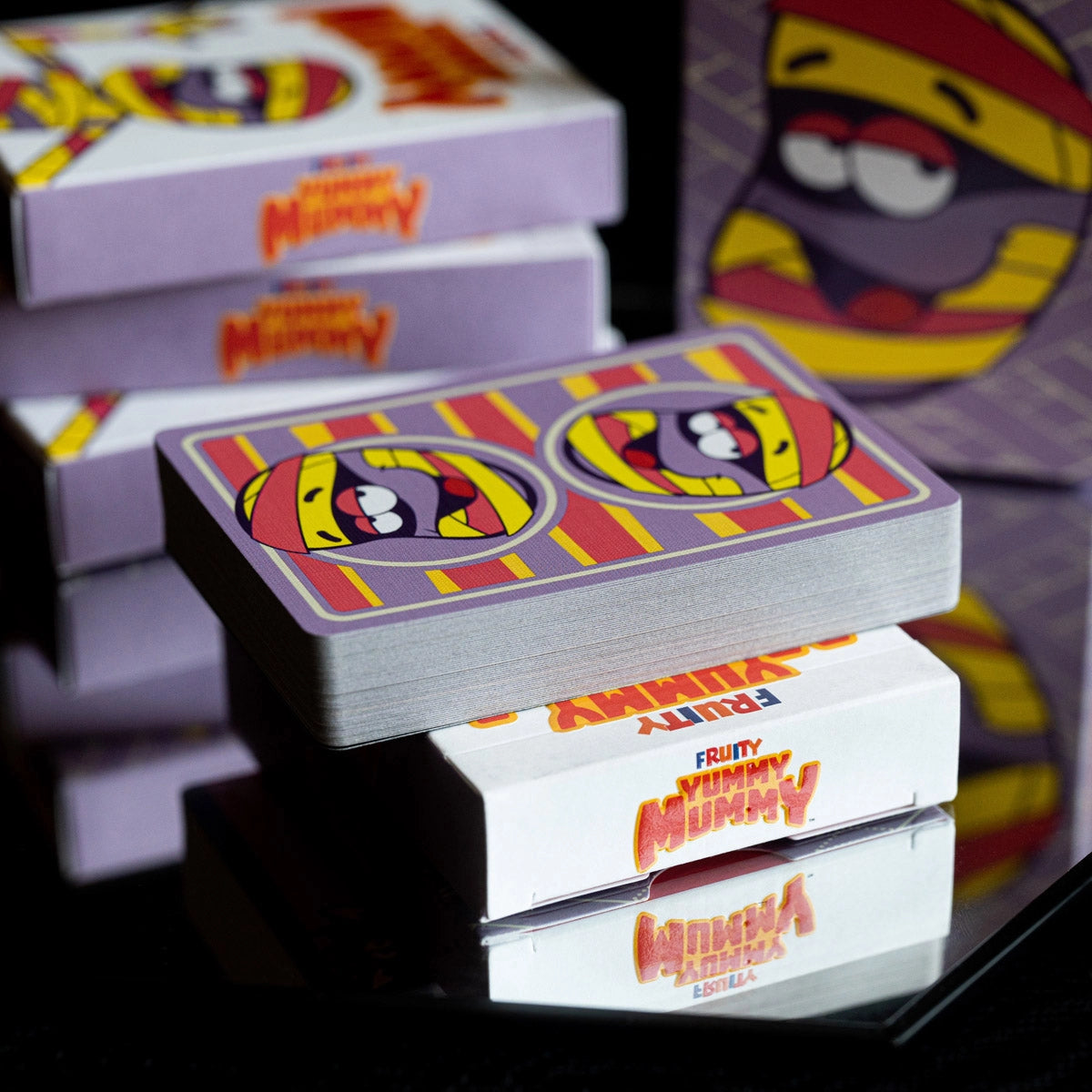 Fruity Yummy Mummy deck resting horizontally on a tuck box with the two-way card back visible.