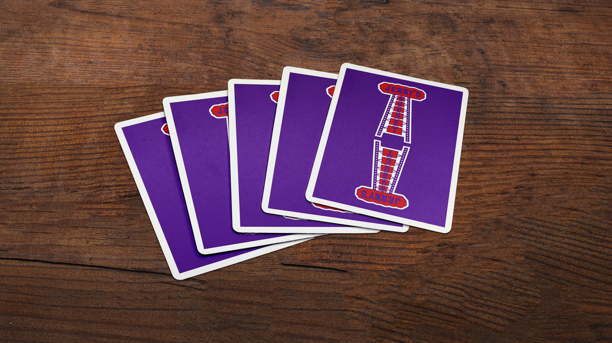 Several Jerry’s Nugget Royal Purple card backs spread across a wooden surface.