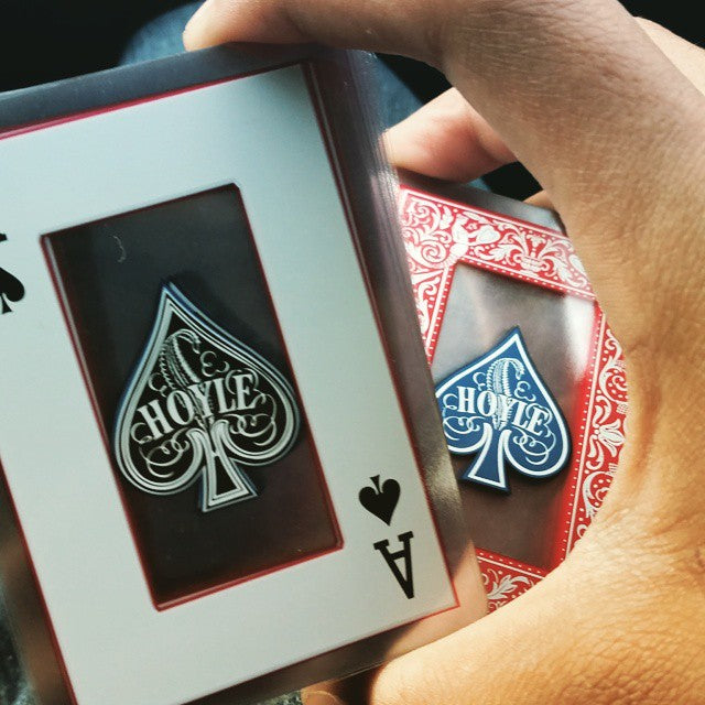 Hand holding a deck of Hoyle playing cards with a focus on the ace of spades.