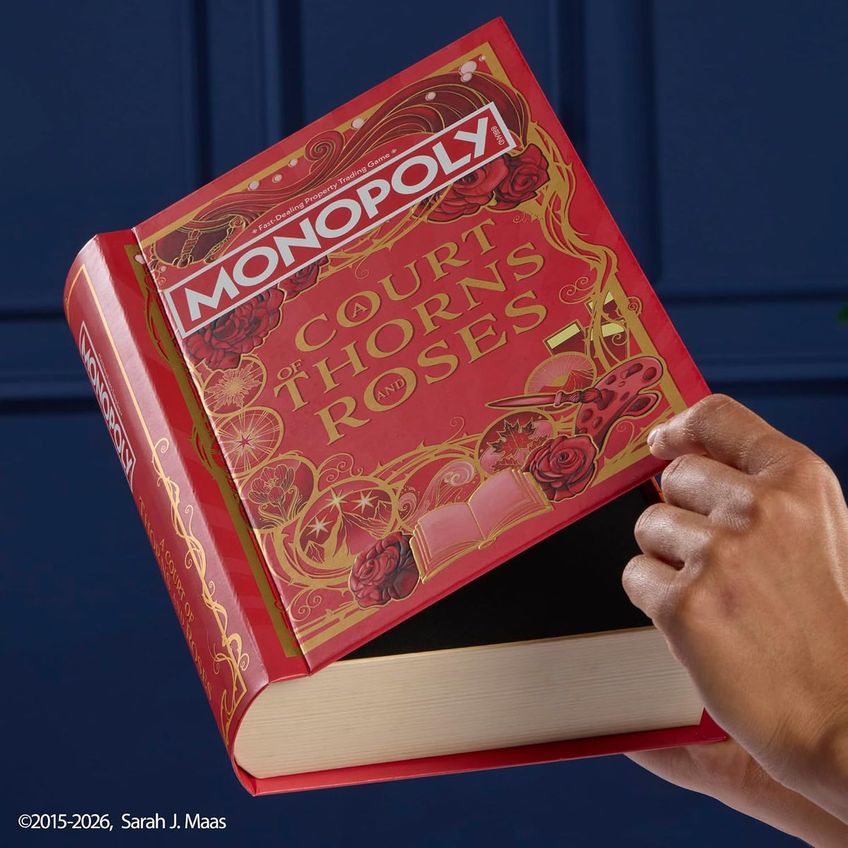 Red book-style packaging for Monopoly A Court of Thorns and Roses being displayed upright.