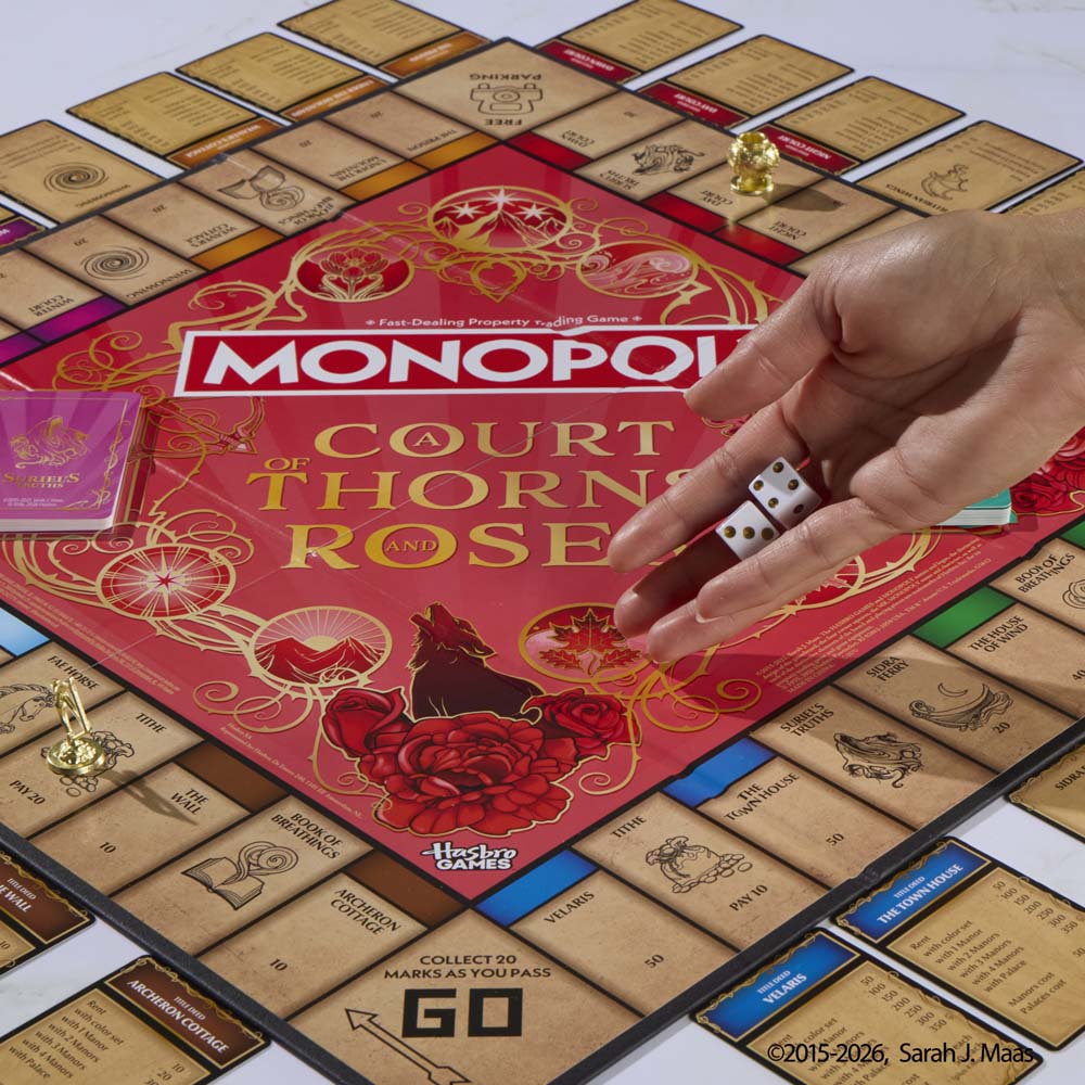 A player rolls dice on the Monopoly A Court of Thorns and Roses gameboard.