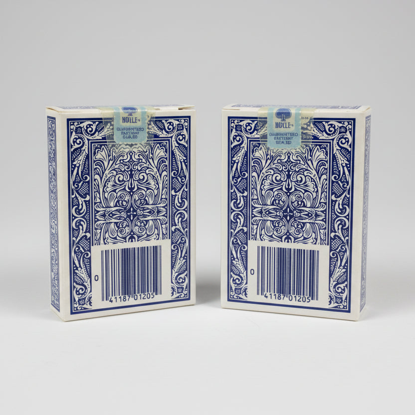 Two blue Maverick playing card decks with decorative designs on a dark surface