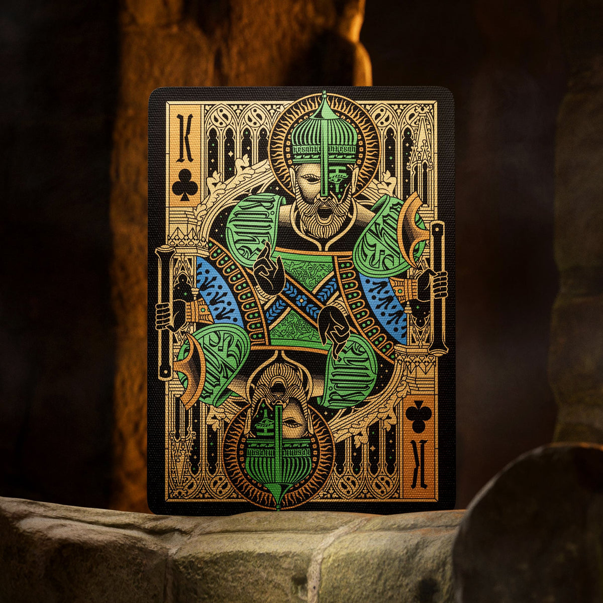 Theory11 Kovadrin King of Clubs with green armor, blue accents, and intricate gold details against a black background.