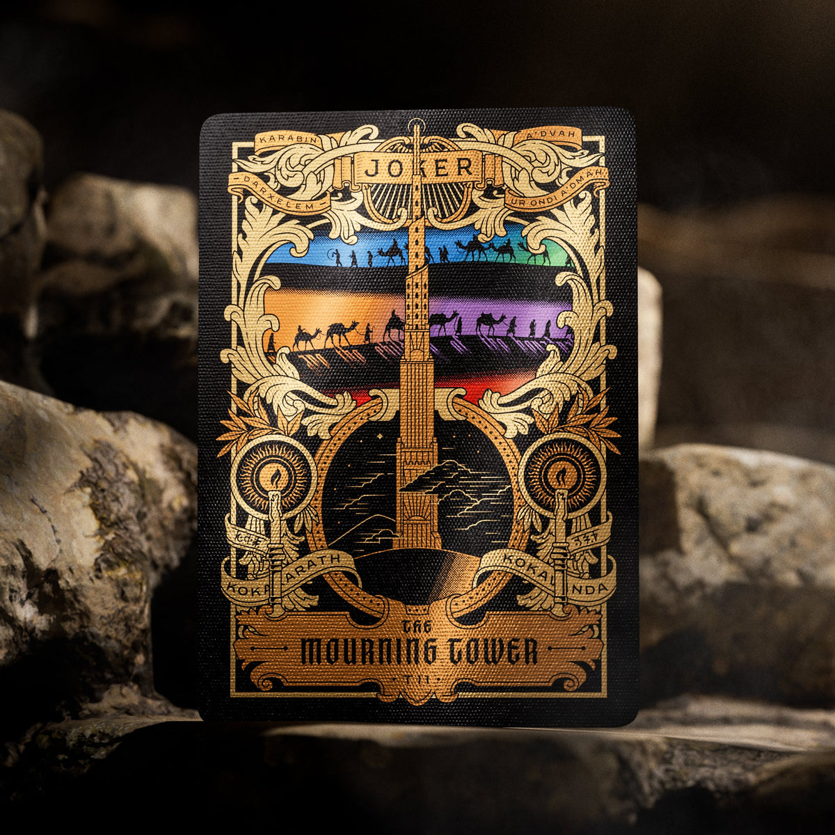Theory11 Kovadrin Joker featuring the Mourning Tower, a gold ornamental frame, and multicolor panels with silhouetted figures.