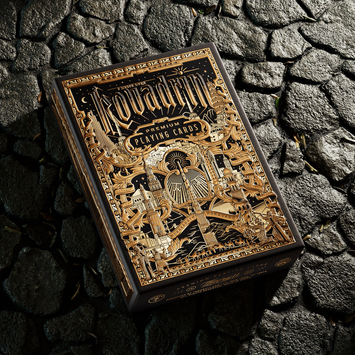 Theory11 Kovadrin Standard Edition tuck box with gold architectural artwork and ornate lettering, resting on dark stone.