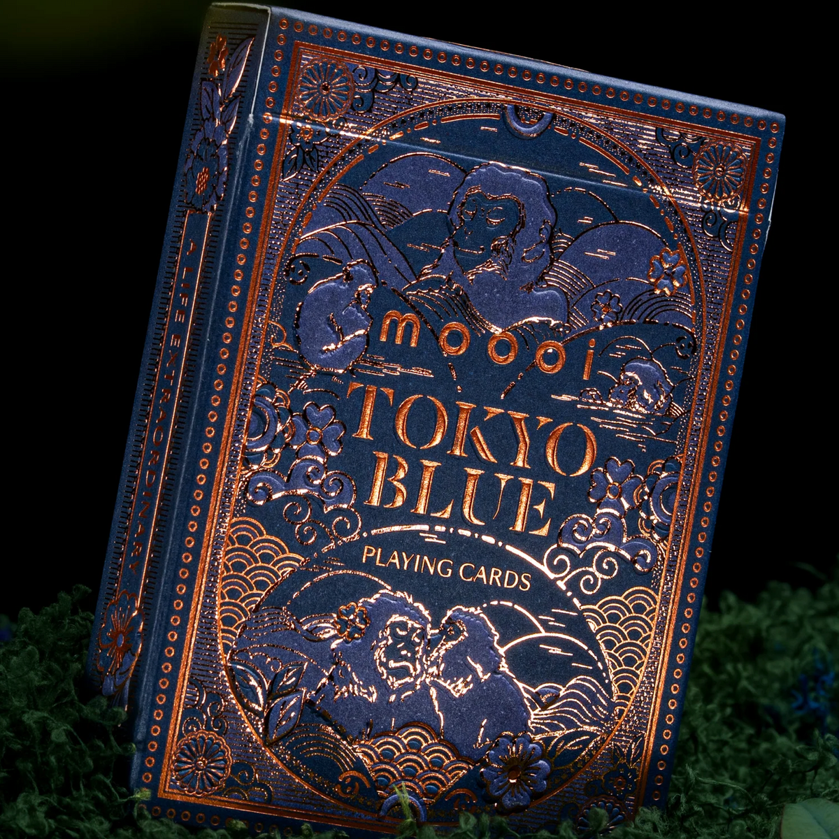 Angled view of the Moooi Tokyo Blue tuck box highlighting reflective bronze foil lettering, macaques, and floral details.