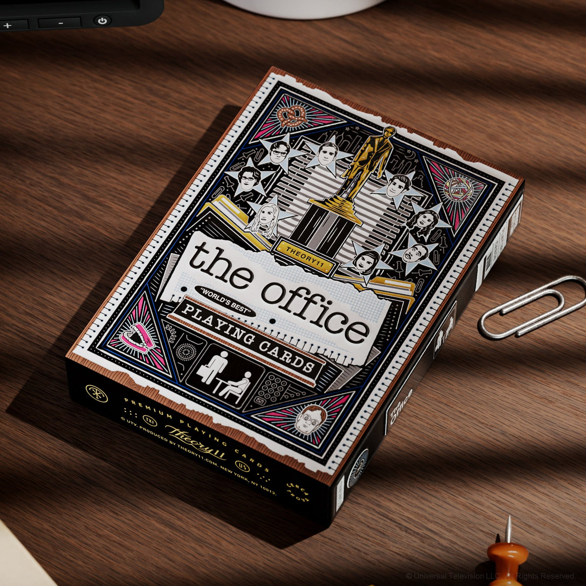 The Office Playing Cards tuck box lying on a desk with its illustrated front facing up