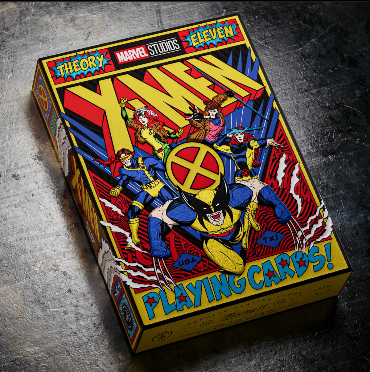 Angled view of the theory11 X-Men tuck box on a metal surface, showing the illustrated front, side, and bottom panel.