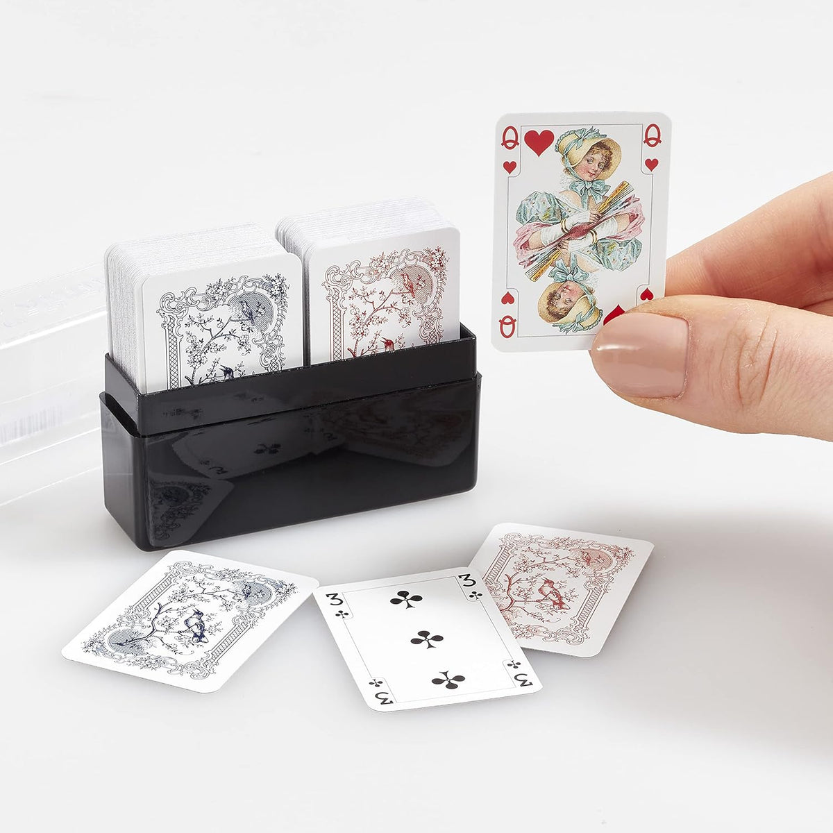 Set of Piatnik miniature patience and solitaire playing cards with a black card holder on a white background