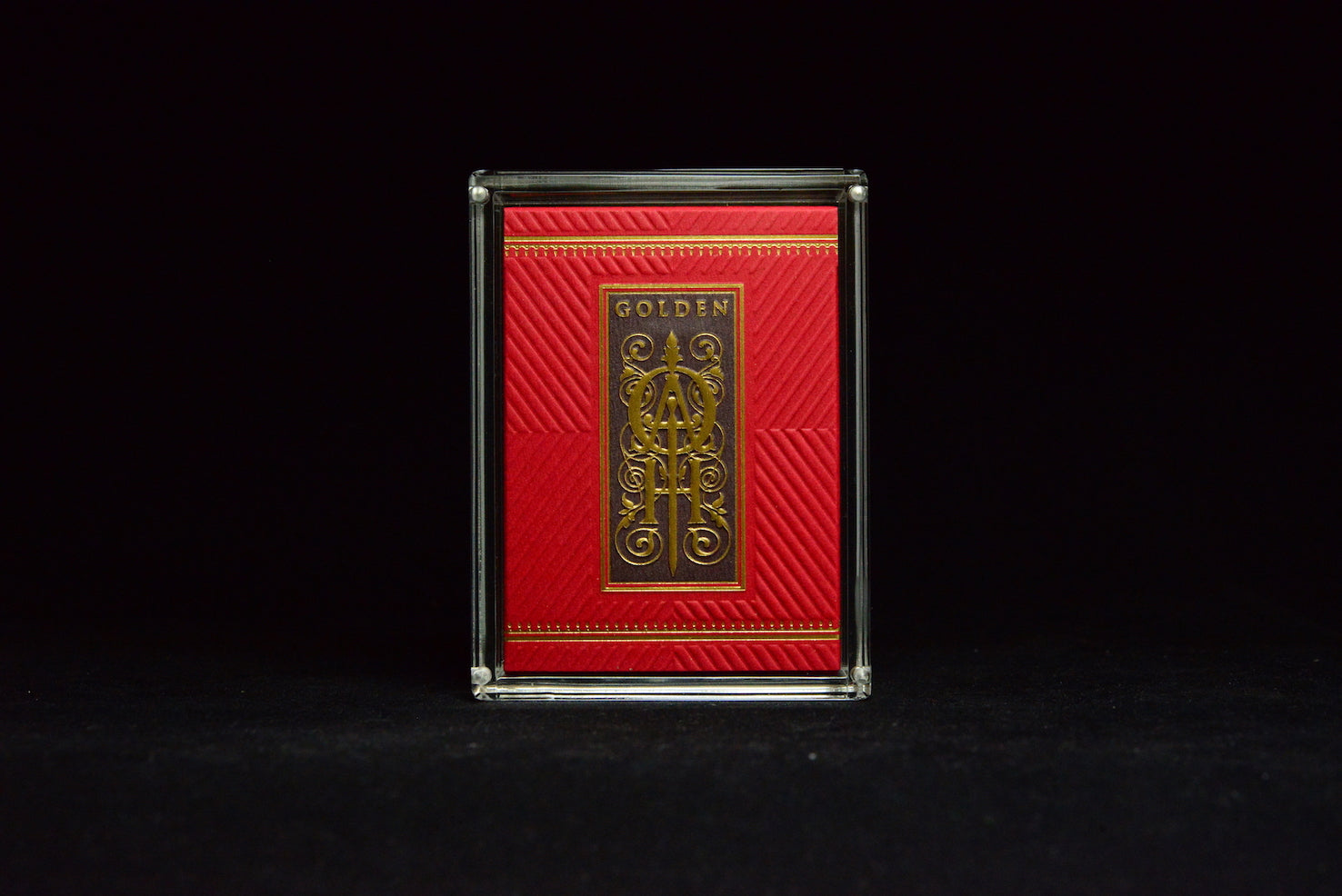 Red playing card box with gold text on a black background