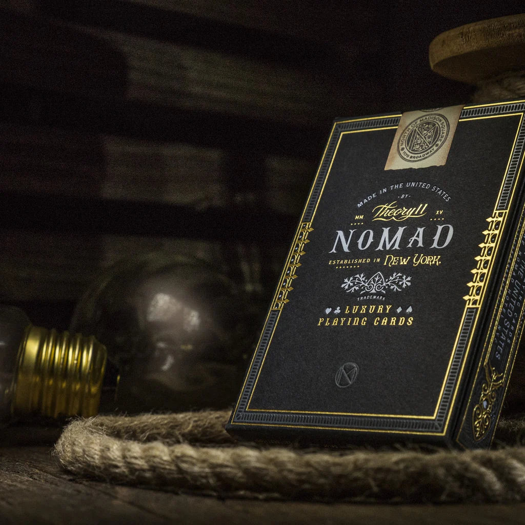 Theroux Nomad New York luxury playing cards on a rustic background with a light bulb.