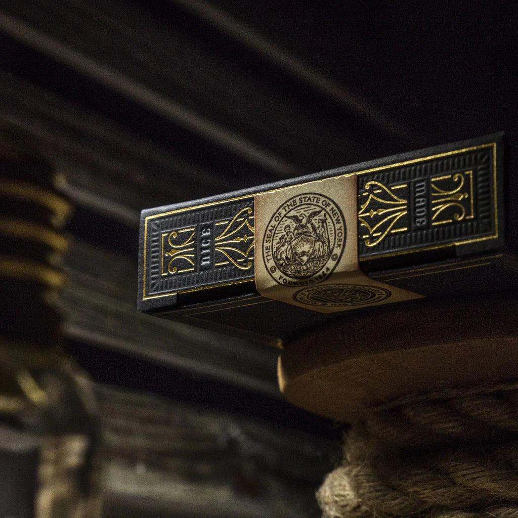 Close-up of a gold and black playing card with a detailed design on a dark background