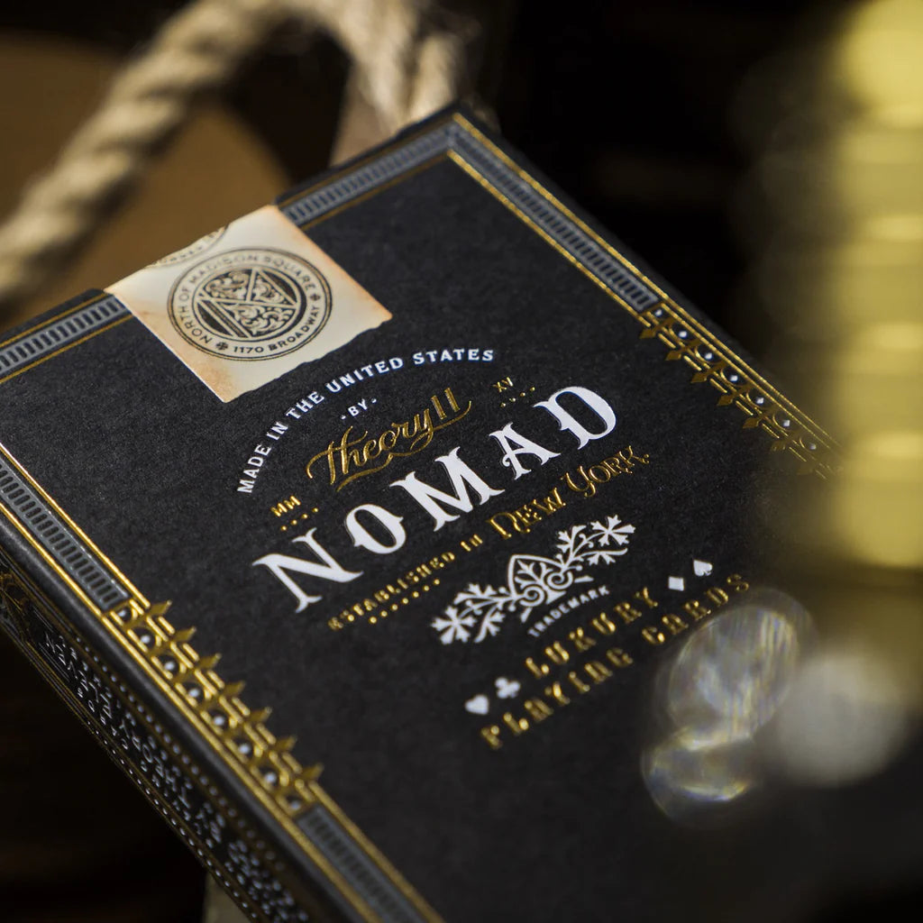Luxury playing card box with 'Nomad' branding on a dark background