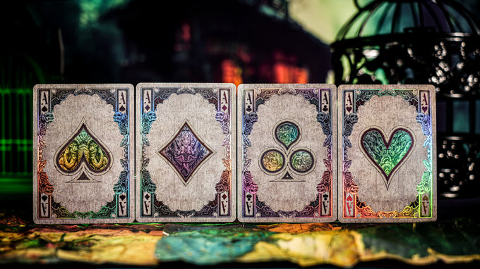 Four playing card aces with different suits on a colorful surface.