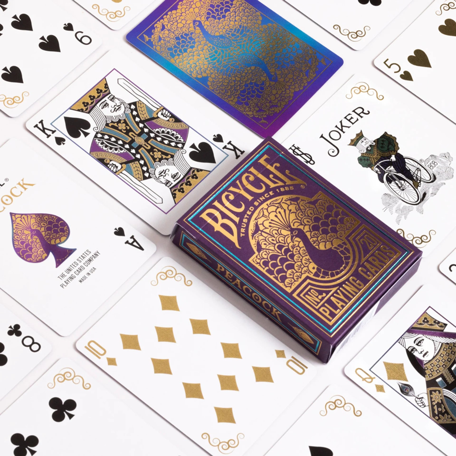 Bicycle Peacock playing cards with a purple and gold design on a white background.