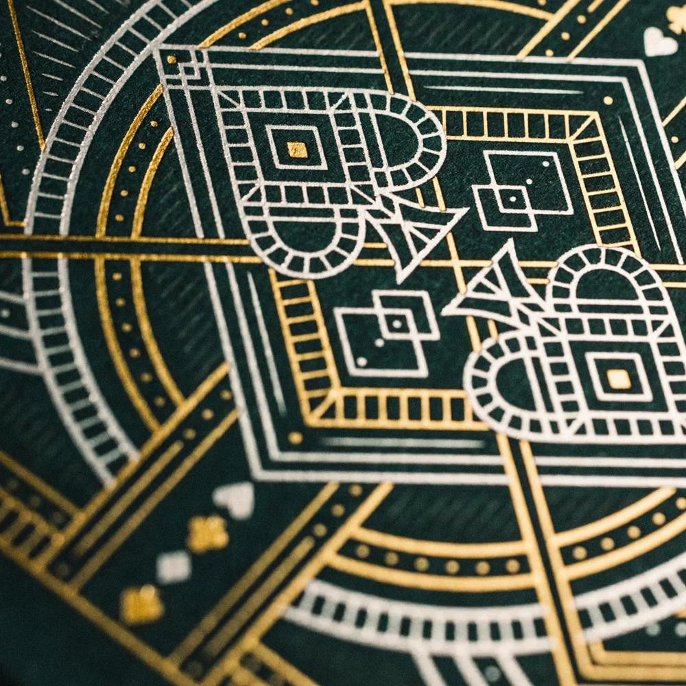 Close‑up detail of Bicycle Byzantine card back showing intricate gold and white geometric pattern on dark green background.