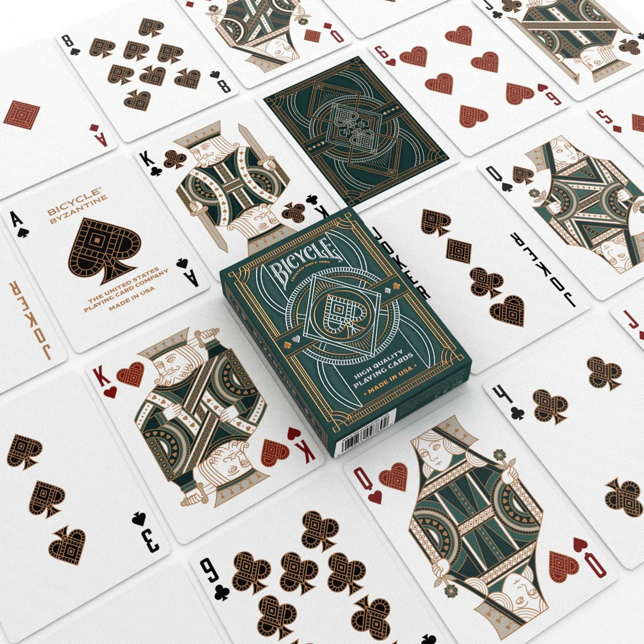 Bicycle Byzantine deck on table surrounded by custom courts and pips in green, bronze, and cream color palette.