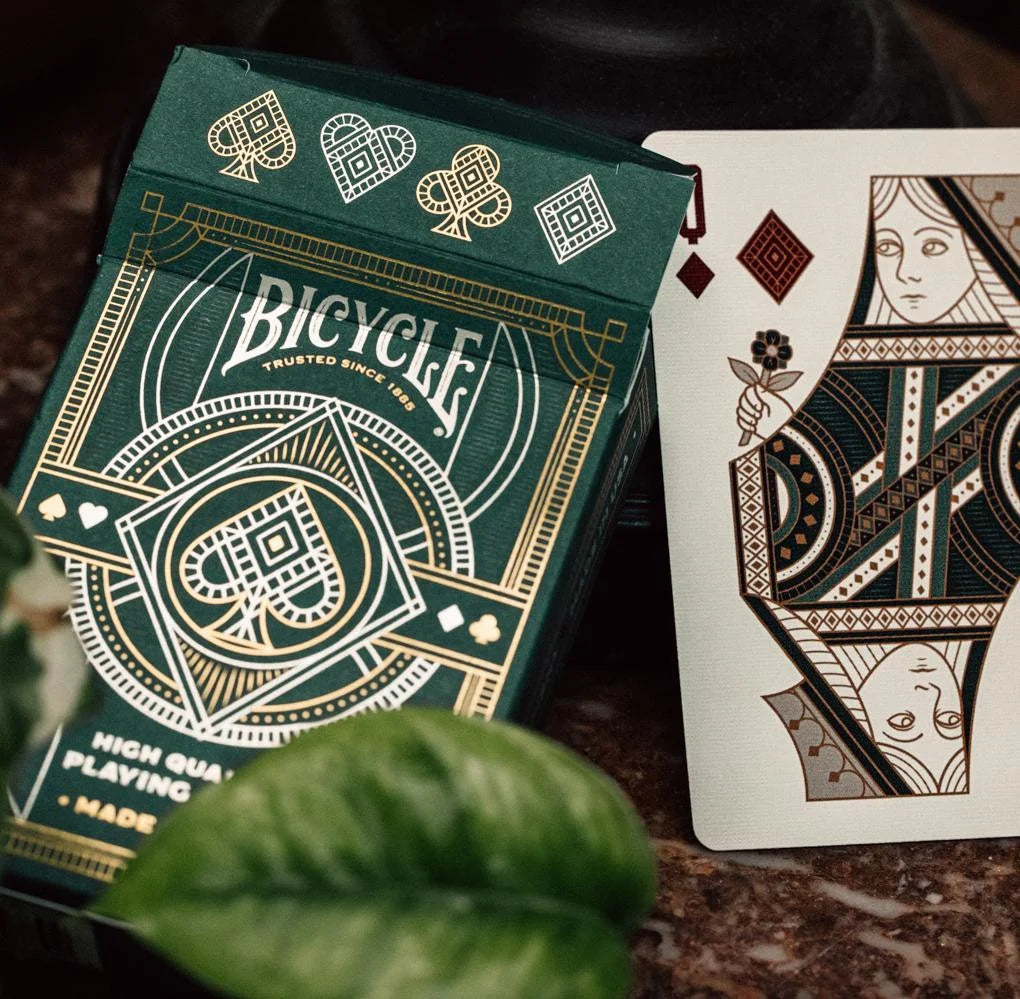Bicycle Byzantine tuck box next to custom diamond Queen court card, highlighting rich emerald and bronze artwork.