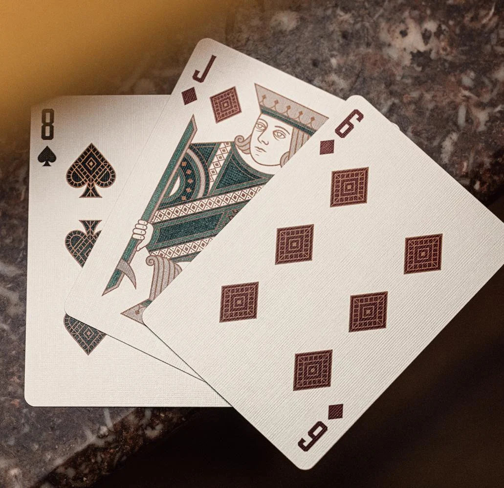Fan of Bicycle Byzantine playing cards showing custom Jack of Diamonds, 8 of Spades, and 6 of Diamonds with tiled pips.