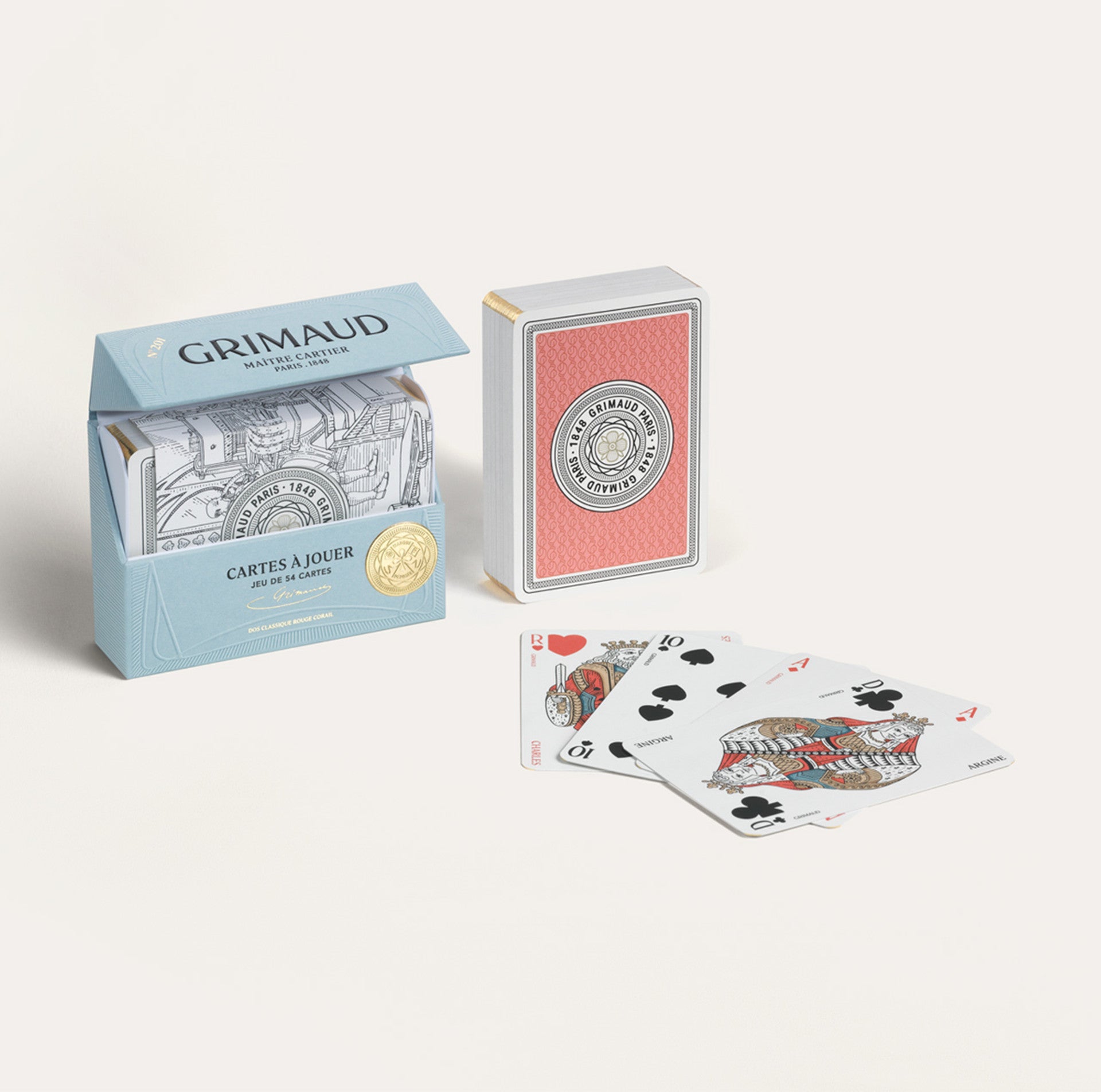 Two boxes of Grimaud playing cards with a few cards laid out in front on a white background.