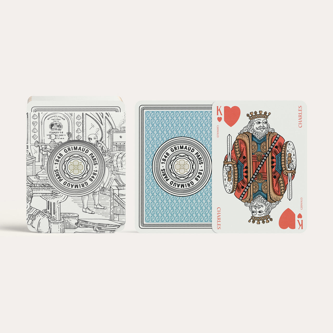 Three playing cards from the Grimaud N°300 Coffret Bridge deck on a white background