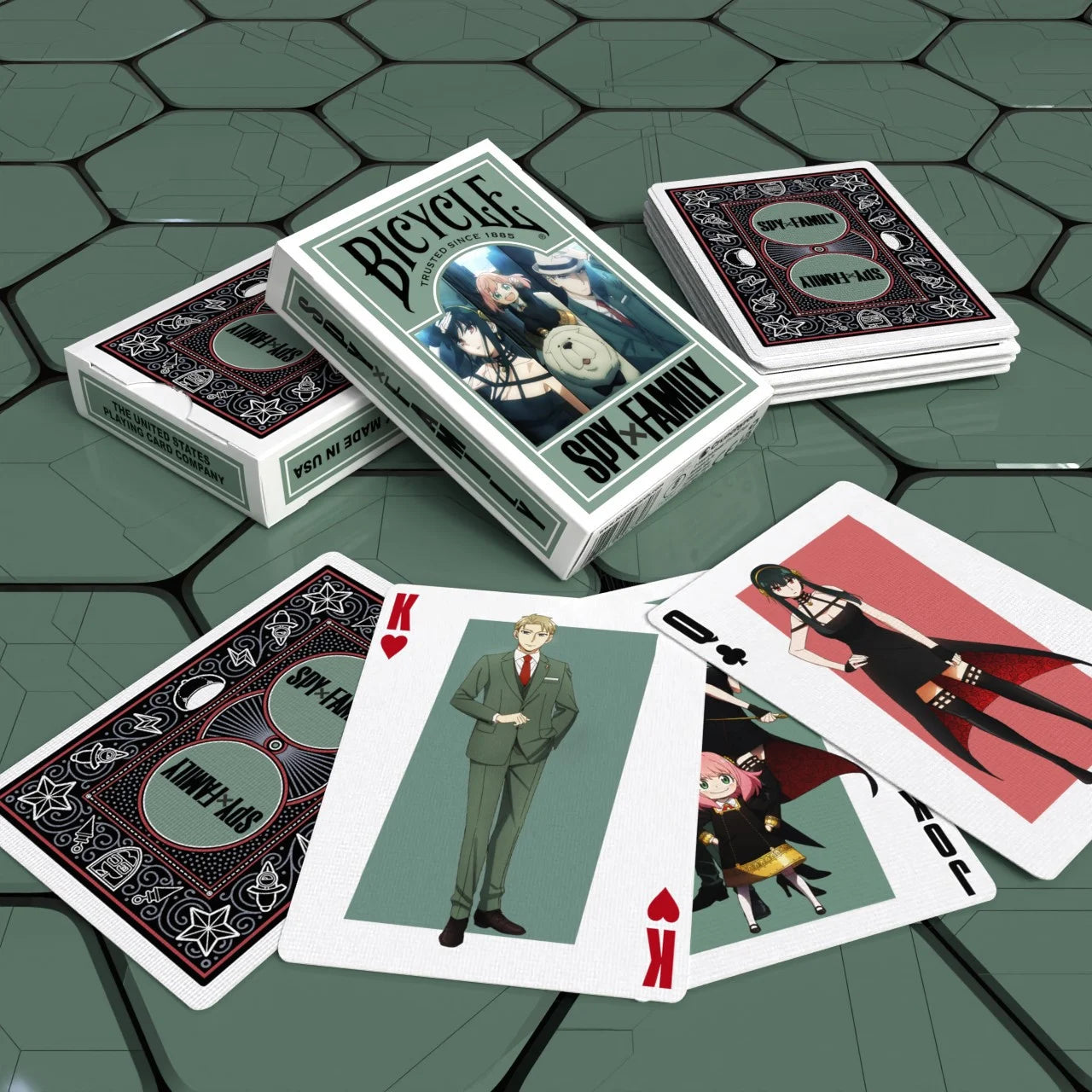 Bicycle Spy x Family tuck box on green table with King, Queen, and Joker cards featuring Loid, Yor, and Anya Forger.