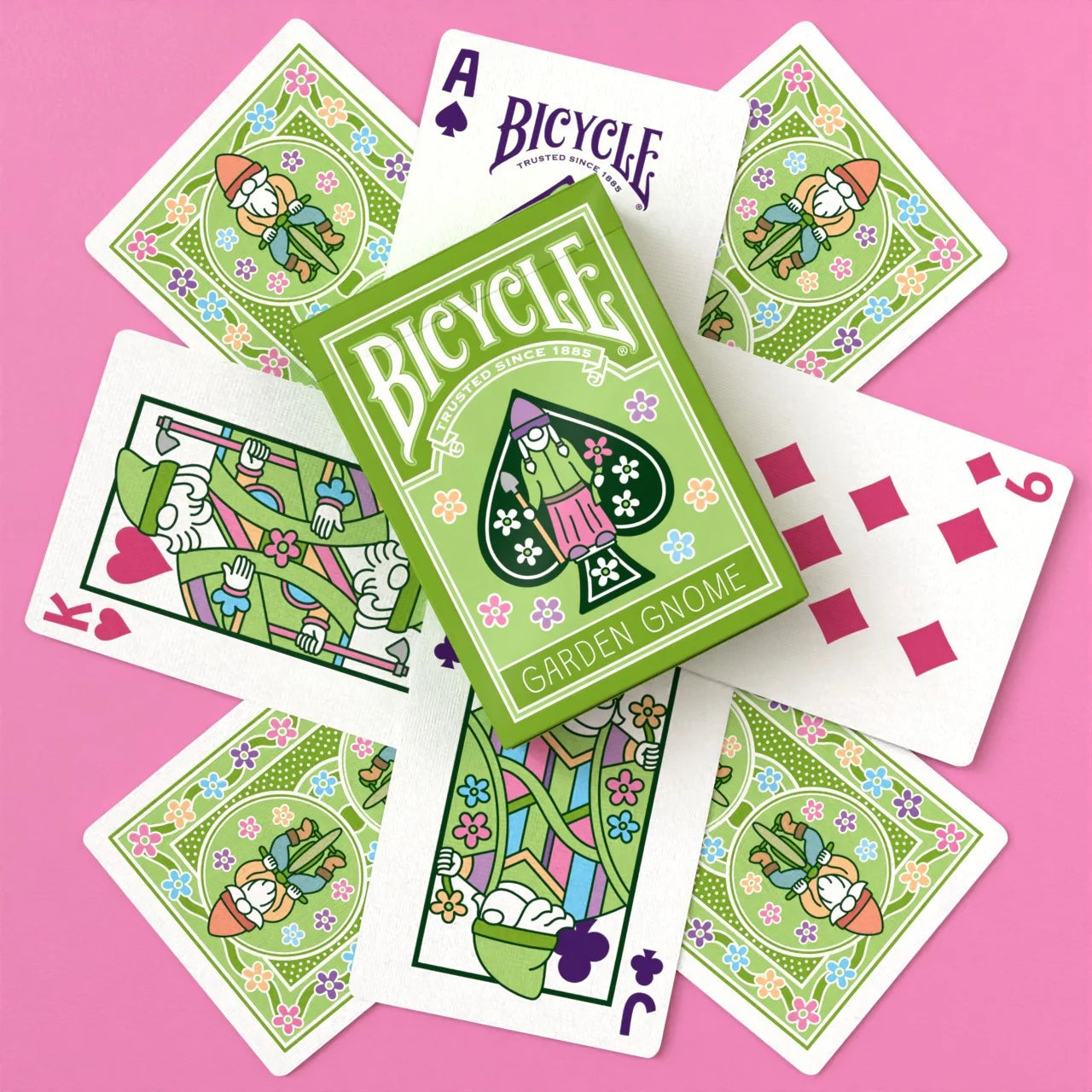 Bicycle Garden Gnome Playing Cards flat lay with green tuck box, custom gnome courts and floral-themed pips