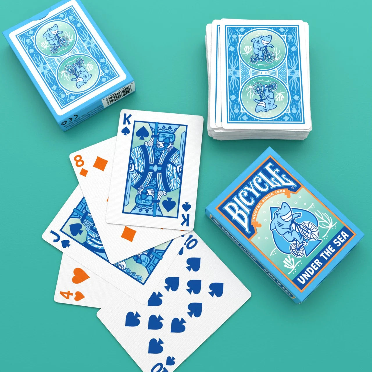 Bicycle Under the Sea playing cards with blue card backs, custom courts, and tuck boxes
