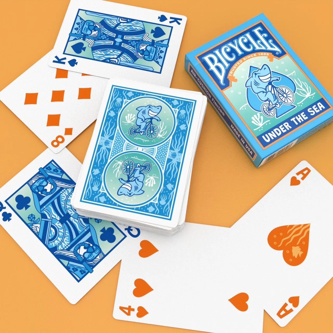 Bicycle Under the Sea playing cards with blue backs, orange pips, and ocean-themed tuck box