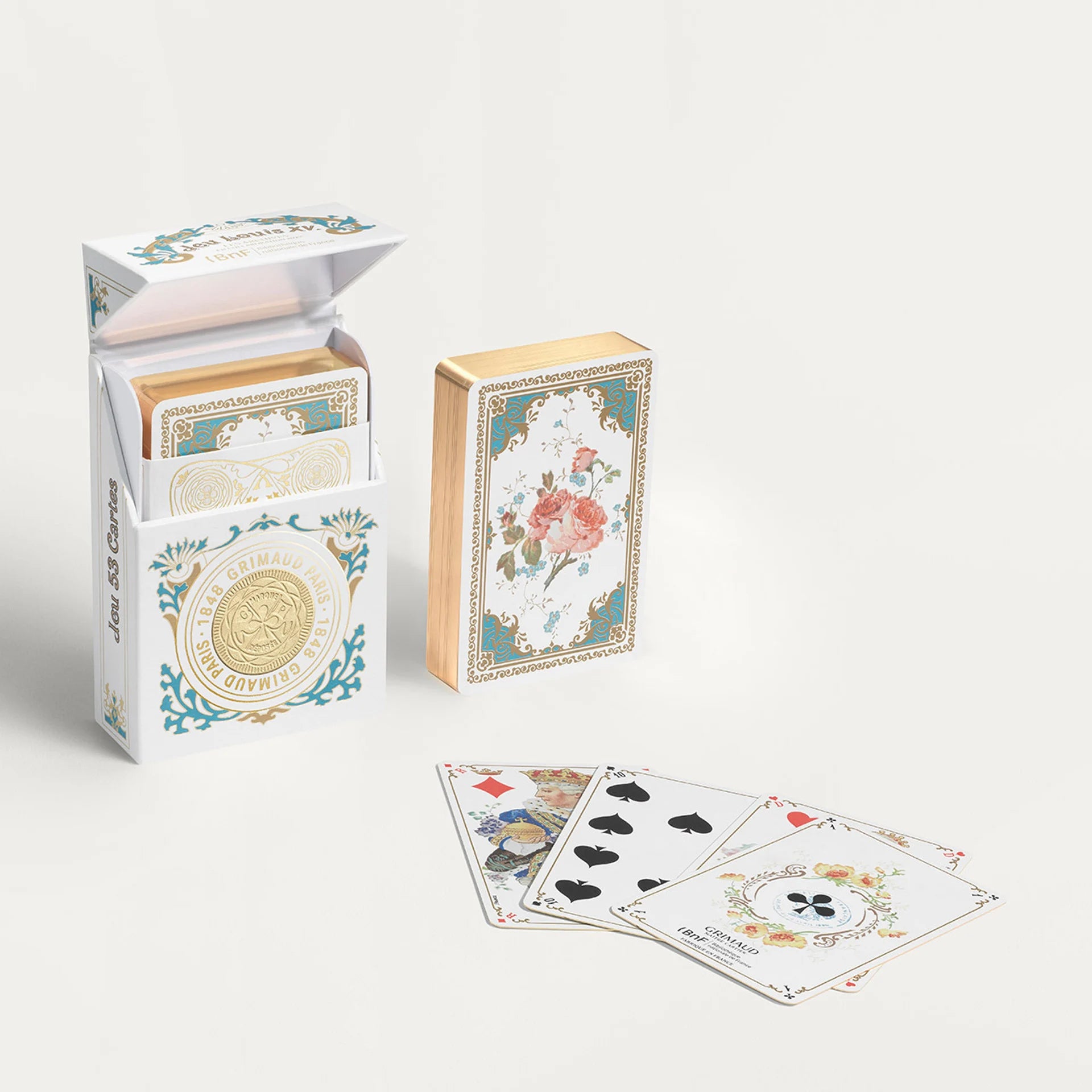 Decorative Grimaud Jeu Louis XV playing cards with floral designs and packaging on a white background
