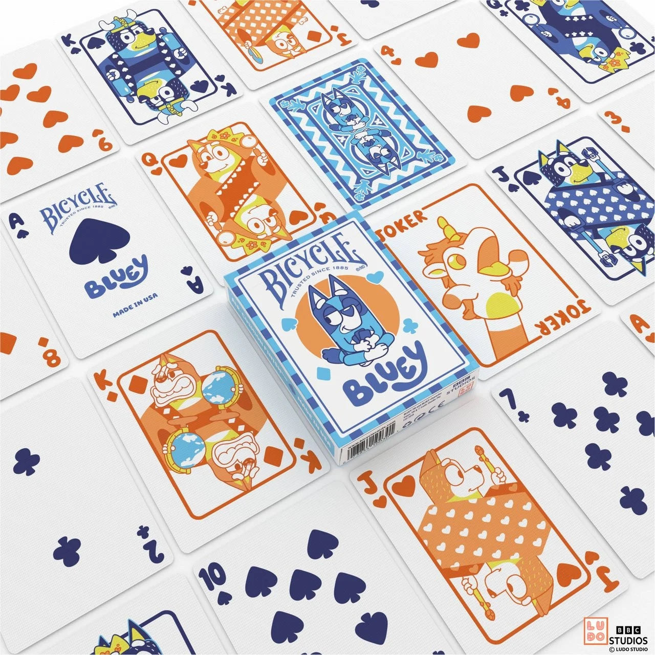 Bicycle Bluey playing cards spread out on blue table with Bluey tuck box and custom blue backs.