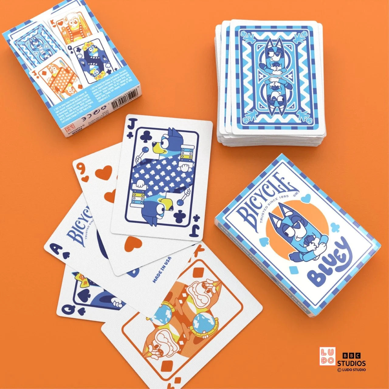 Bicycle Bluey playing cards on orange table with character courts and custom blue card backs.