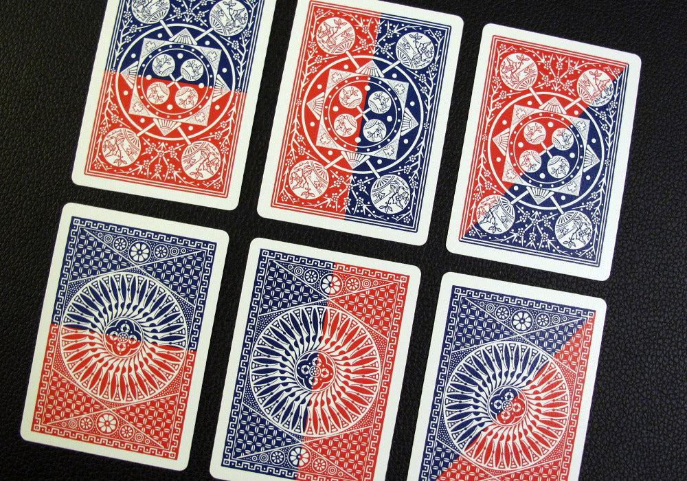 Six playing cards with red and blue designs on a black background