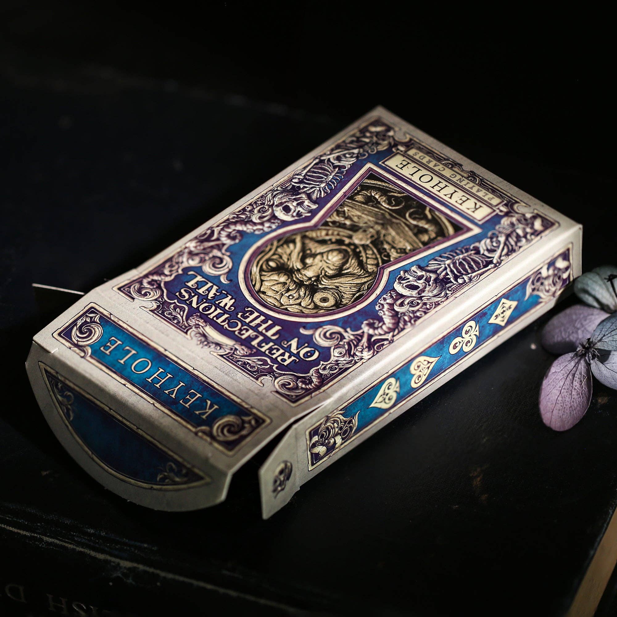 Decorative playing card box with intricate designs on a dark background