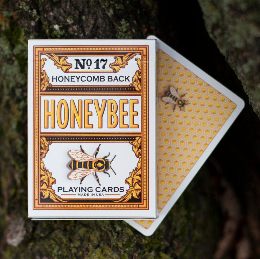 Honeybee playing cards with honeycomb pattern on a textured surface
