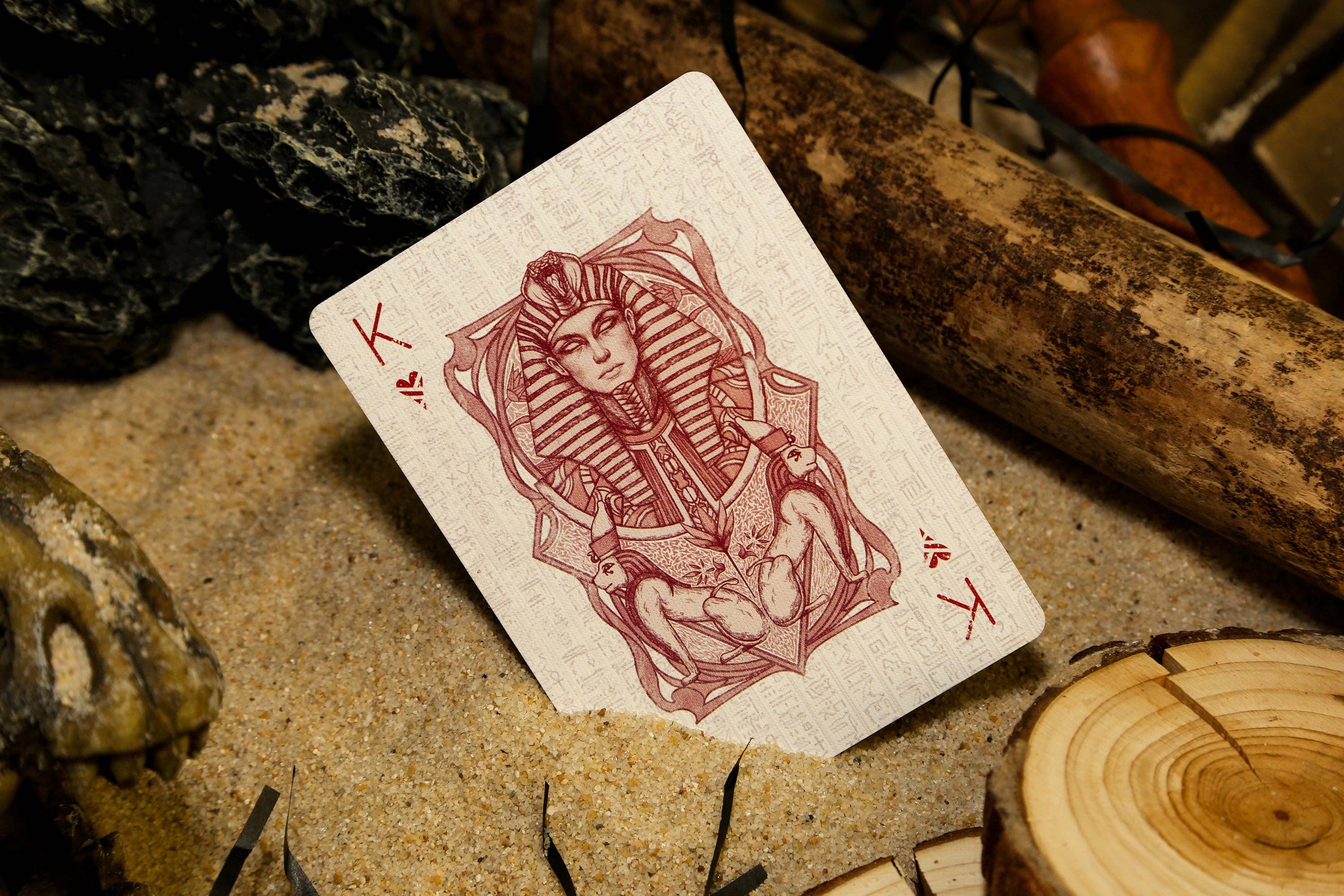 Playing card with a red design of a sphinx on a natural background