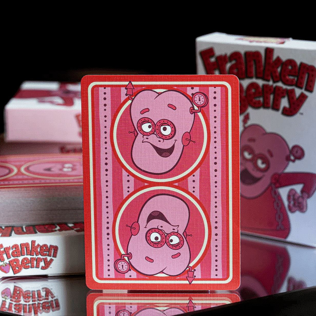 Pink Franken Berry playing card with cartoon character design on a reflective surface