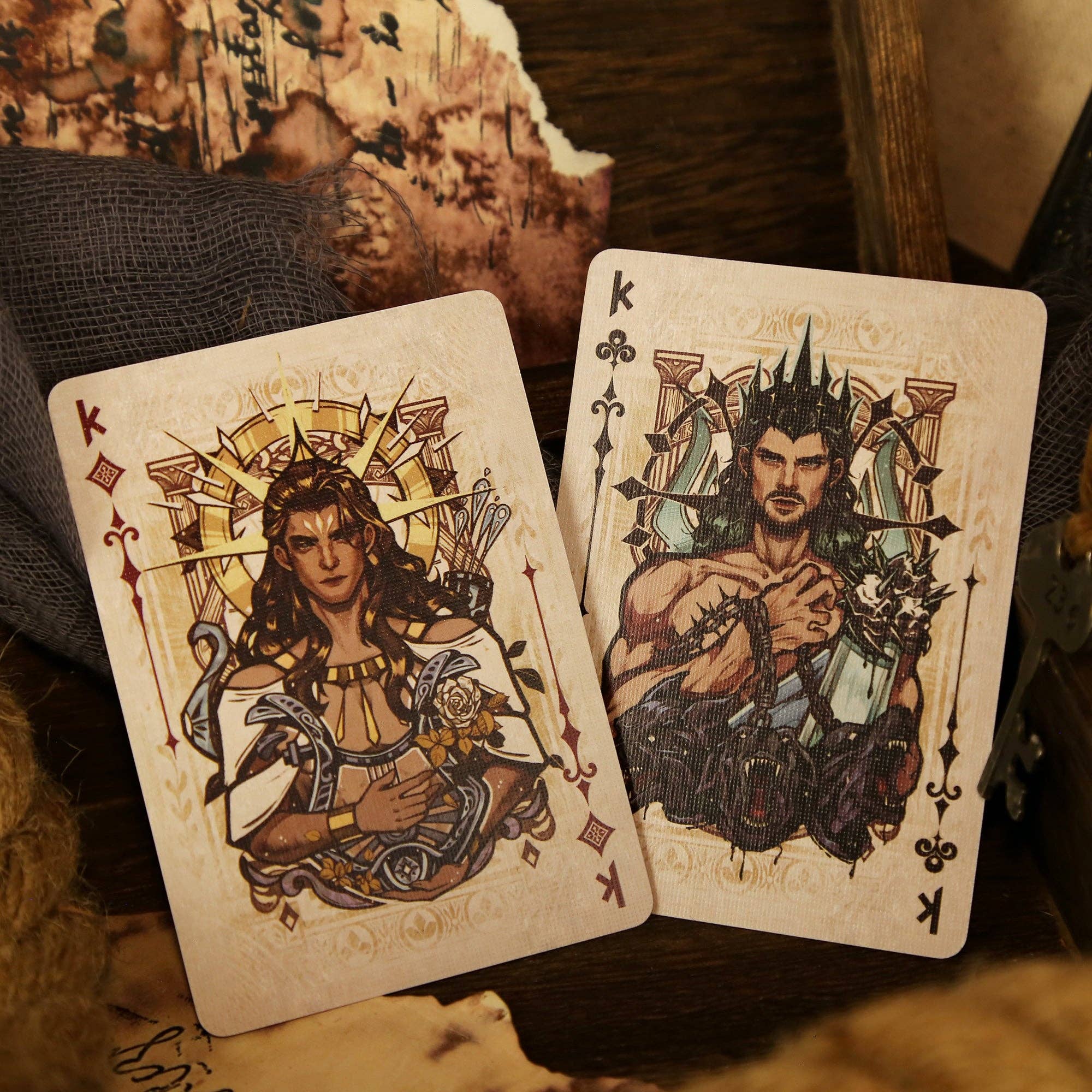 Two playing cards featuring artistic illustrations of warriors on a textured surface.