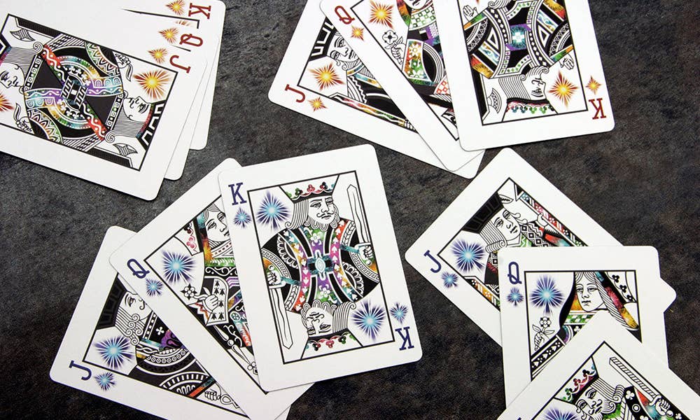 Colorful playing cards with decorative designs on a dark surface