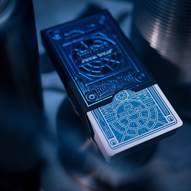 Two playing card decks with intricate designs on a dark background