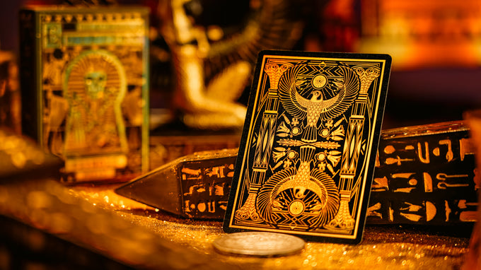 Decorative playing cards with Egyptian-themed design on a wooden surface.