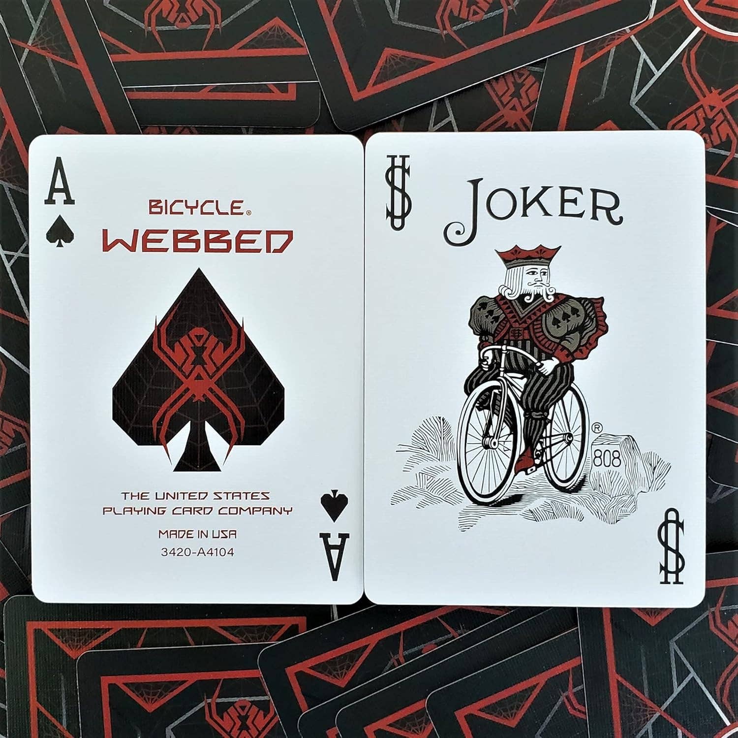 Two playing cards, Ace of Spades and Joker, from the Bicycle Webbed deck on a matching card background.
